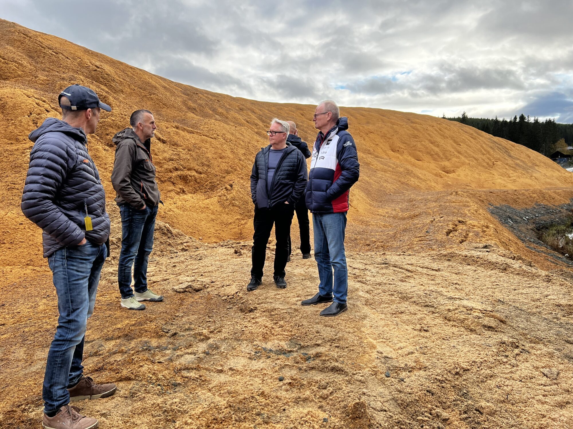 I forbindelse med workshopen til Snow for the future prosjektet, ble det gjennomført en befaring i anlegget hvor snølageret som er dekket med flis ble vist fram. I løpet av november skal snøen kjøres ut i langrennsløypene. Foto: Ingvil Snøfugl